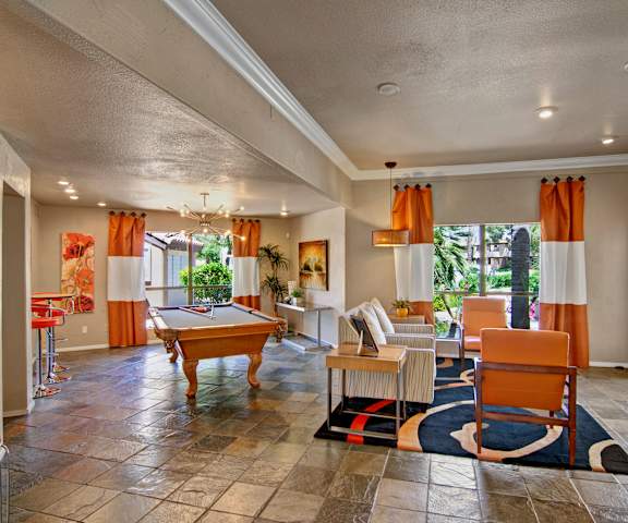 A resident lounge with tables, chairs, and a pool table at Desert Horizon. 