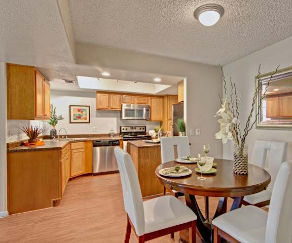 The dining room with a dining table and chairs and a view of the kitchen at Desert Horizon. 