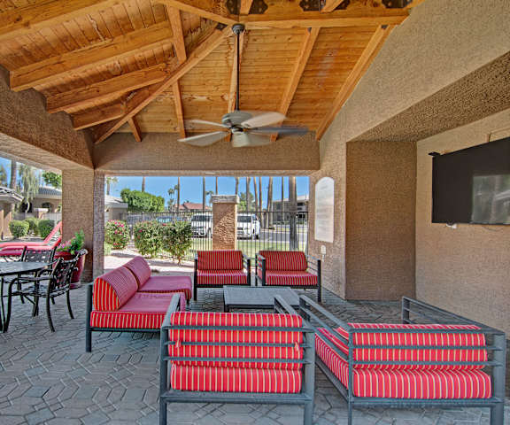 A patio with a red couch and chairs at Reserve at Arrowhead Apartment Homes. 