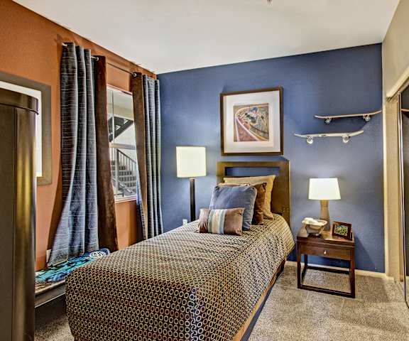A bedroom with a twin bed, closet, dresser, and nightstands at Fresco. 