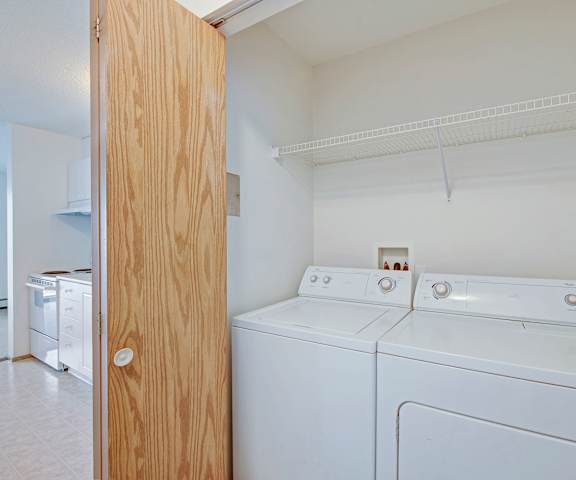 An empty laundry room with a washer and dryer in it at Aspen Terrace. 