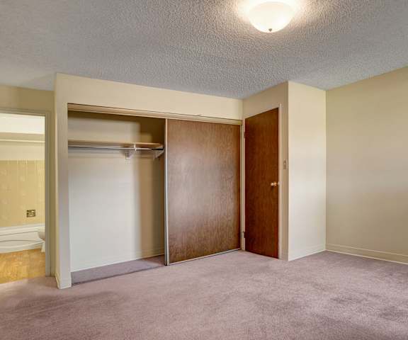 An empty bedroom with a window at Edgemont Heights. 