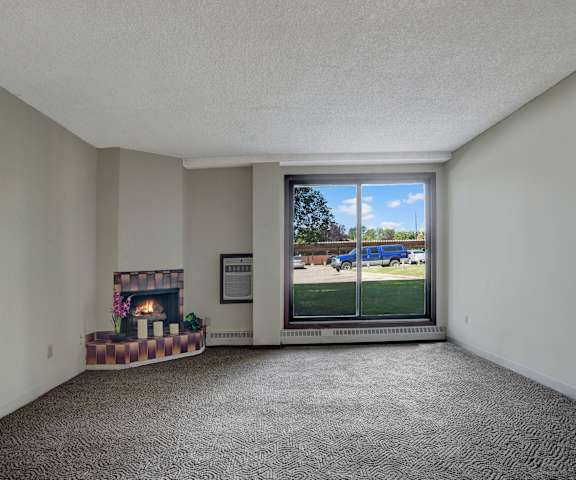 An empty living room with carpeting and a window at Edgemont Heights.