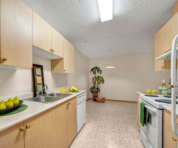 A kitchen with white appliances and counters at Edgewood Estates. 