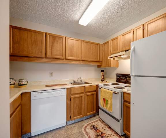A kitchen with wooden counters, white appliances and counters at Gateway Square. 