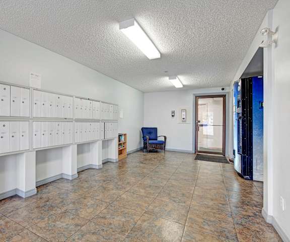 The mailroom with rows of mailboxes, a vending machine, and a blue chair in the corner at Westhaven Estates Apartment Homes. 