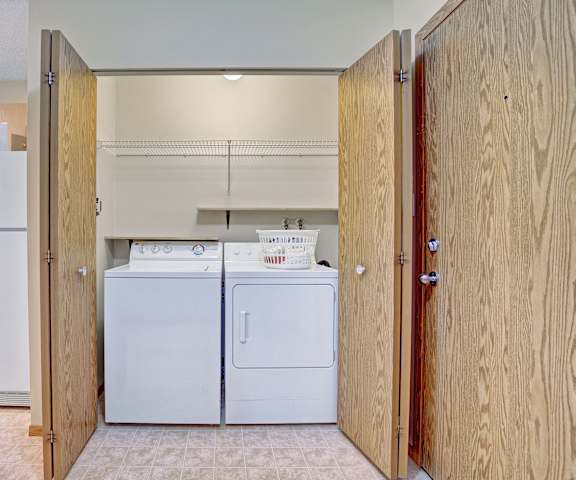 The laundry room with shelves, a washer, and a dryer at Westhaven Estates Apartment Homes. 