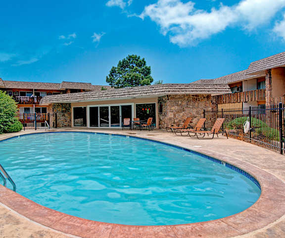 The outdoor pool with pool chairs, tables, and chairs at Copper Stone. 