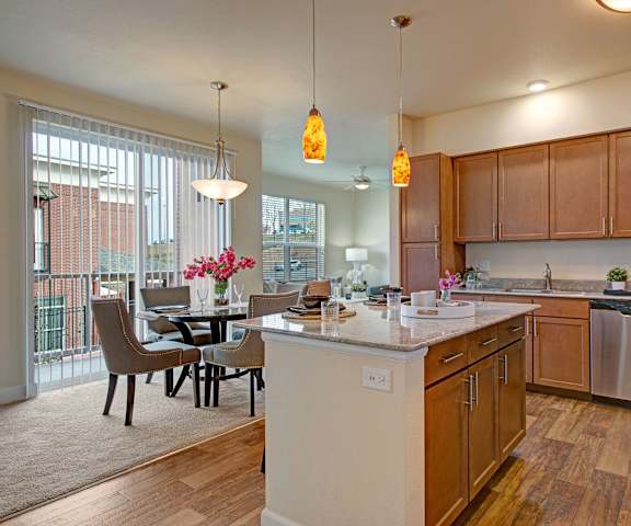 The dining room with a dining table and chairs and a view of the kitchen at Elements at Briargate. 