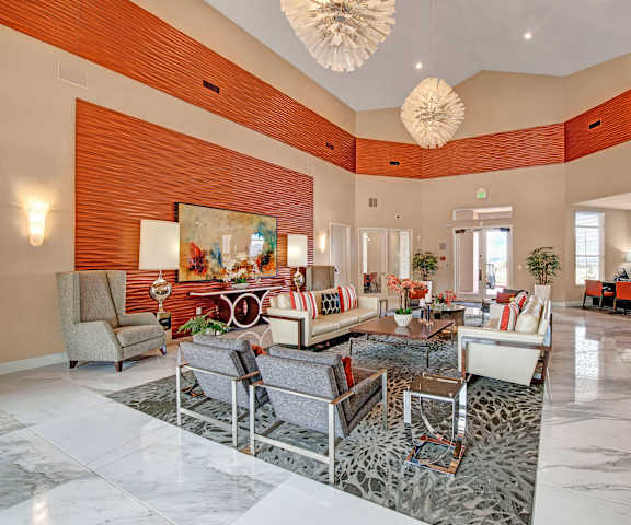 The resident lounge with a fireplace, couches, plush chairs, and coffee tables at Elements at Briargate. 