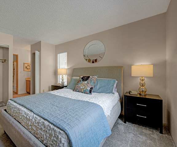 A bedroom with a queen-size bed, closet, and nightstands at Grand View. 