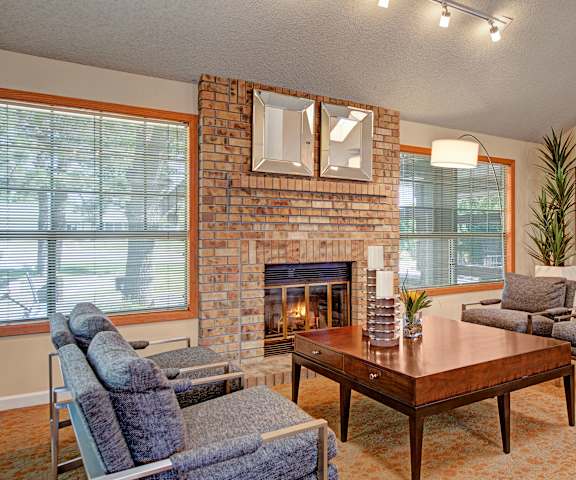 The resident lounge with a fireplace, couches, decorations, plush chairs, and coffee tables at Grand View. 
