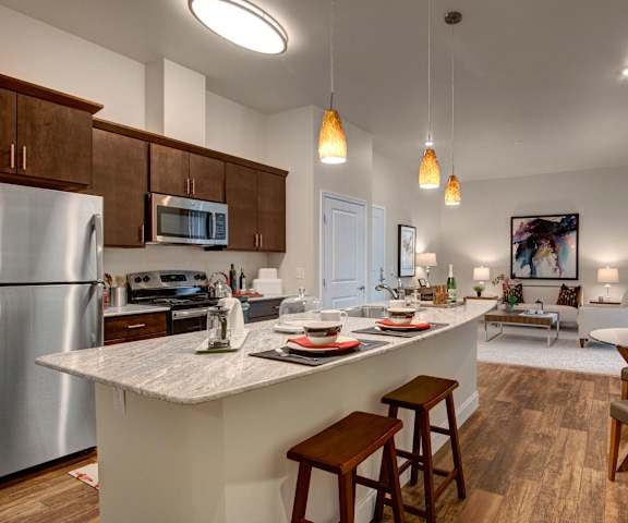 The kitchen and living room at 4800 Excelsior with a fridge, oven, microwave, countertop, couch, and chairs. 