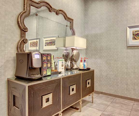 The coffee station with a mirror in the background at Lofts at Farmers Market Apartments. 