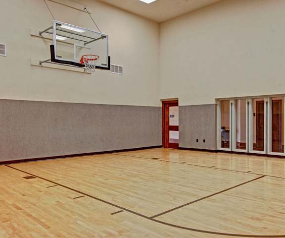 The large basketball court with a hoop and net at Stoneleigh at the Reserve Apartment Homes. 