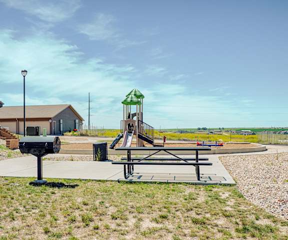 Tons of amenities including Picnic area and Playground A playground at a park at Dakota Ridge Apartments.