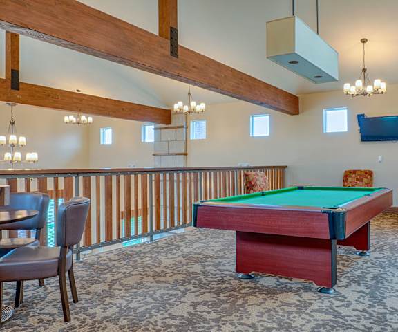 Resident Game room with pool table and plenty of seating A resident lounge with tables, chairs, and a pool table at Dakota Ridge Apartments.