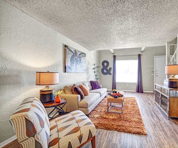 The living room with a couch, coffee table, and decorations at Brookwood Village Apartments. 