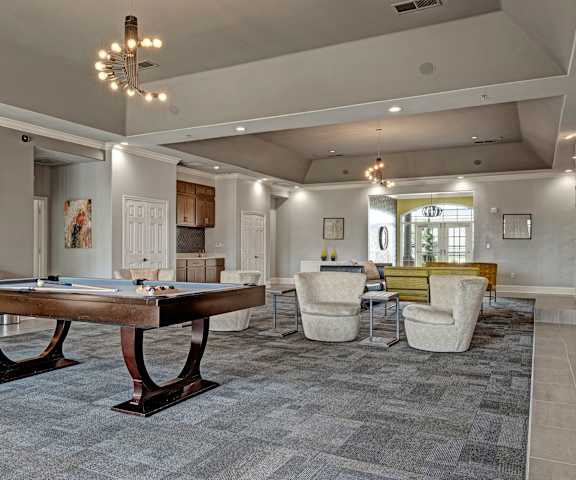 A resident lounge with tables, chairs, and a pool table at Lincoln at Central Park Apartment Homes. 