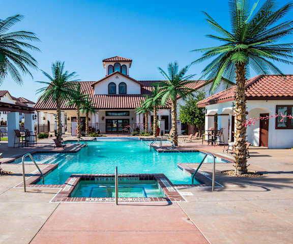 Pool surrounded by chairs and palm trees at Andalucia Villas. 