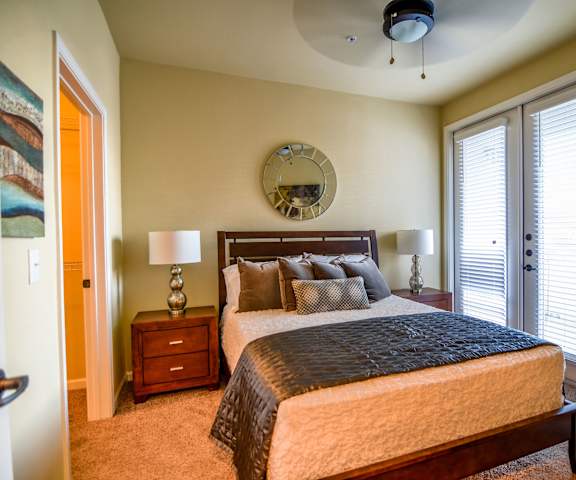 Master bedroom with a queen size bed, nightstands, and a balcony at Andalucia Villas. 