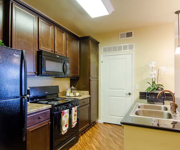 Kitchen at Andalucia Villas with granite countertops and black appliances. 
