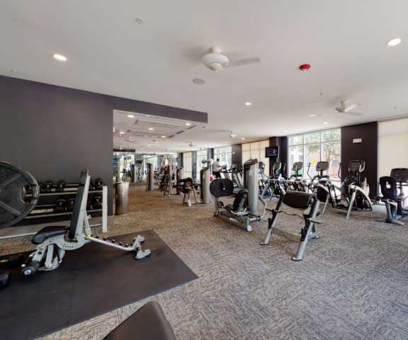 Indoor gym with cardio machines and weights at Arpeggio. 