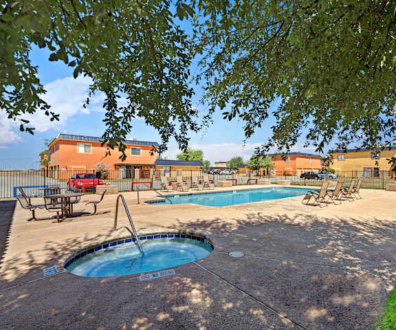 Pool and hot tub at Avanti Townhomes with pool chairs surrounding it. 