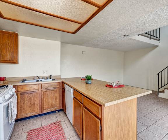 Kitchen at Avanti Townhomes with light cabinets and white appliances. 