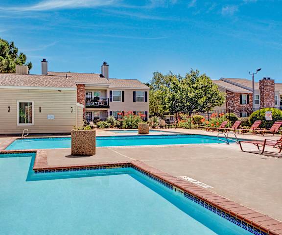 The outdoor pool with pool chairs, tables, and chairs at Cypress Pointe Apartments. 