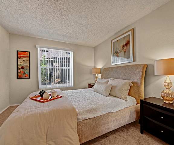 A bedroom with a queen-size bed, closet, and nightstands at Cypress Pointe Apartments. 