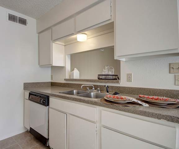 A kitchen with wooden cabinets and marble countertops at Fairgreen. 