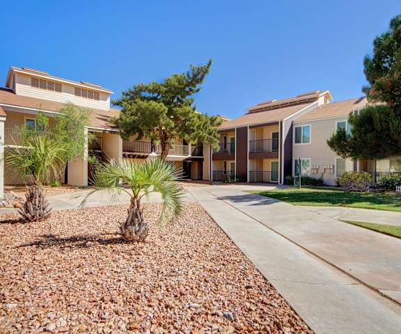 The patio with walkways and trees at Fairgreen Apartment Homes. 