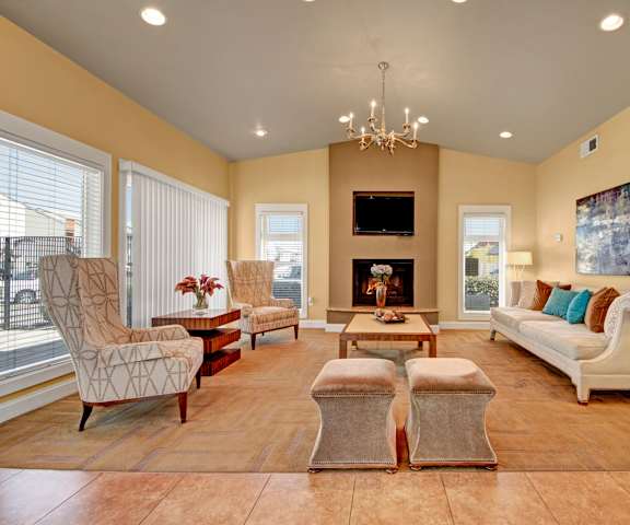 The resident lounge with a fireplace, couches, decorations, plush chairs, and coffee tables at High Plains Apartments. 