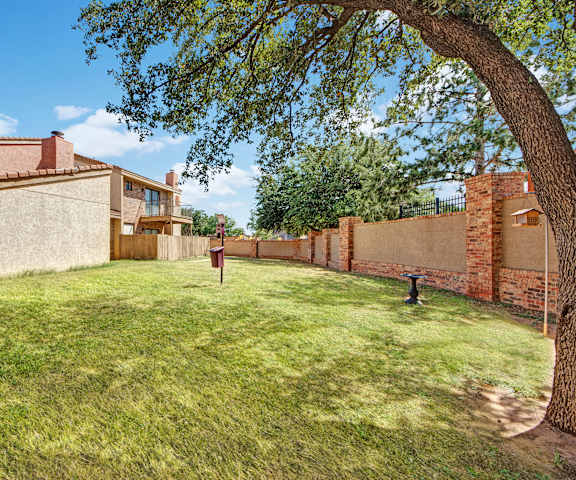 The dog park with greenery and trees at Las Colinas Apartments. 