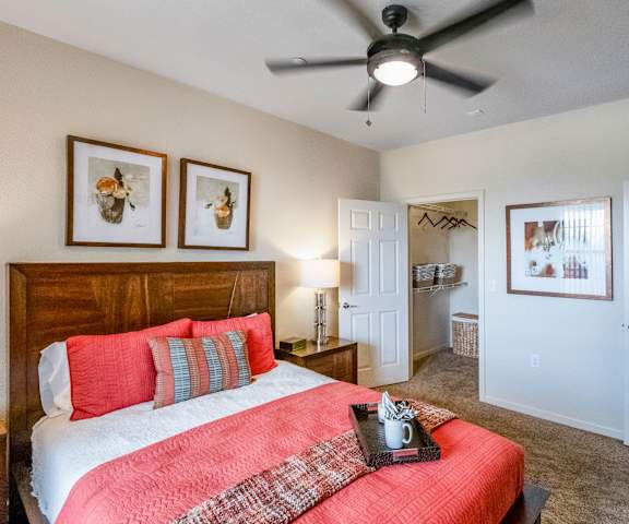 A bedroom with a queen-size bed, a dresser, decorations, closet, and nightstands at Le Mirage Apartments.