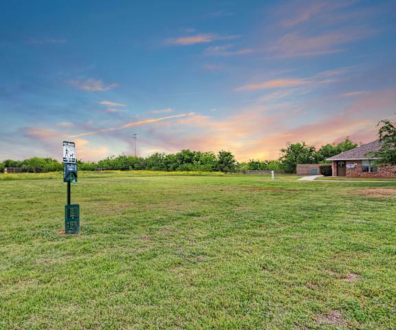 The grassy, open dog park and green area at Lexington Court Apartment Homes. 