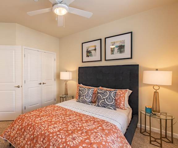 A bedroom at 600 Riverside with a bed, nightstands, lamps, and a closet. 