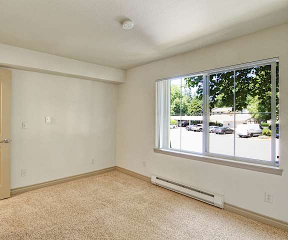 An empty bedroom with carpet and a large window at Asbury Park. 