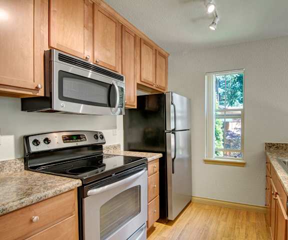 An empty kitchen with granite counter tops and stainless-steel appliances at Asbury Park. 