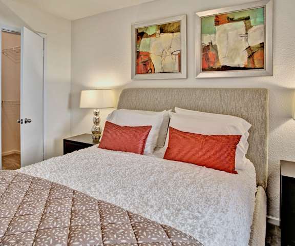A bedroom with a queen-size bed, closet, and nightstands at Breckenridge apartments. 