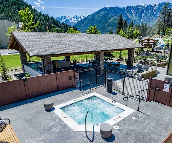 The arial view of a hot tub and outdoor seating area with the Cascade mountains in the background at Leavenworth Haus Apartments. 