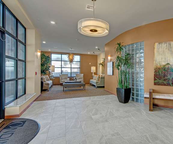 The front entrance to the apartment building at Ondine at Juanita Bay Apartments with a view of the resident lounge and windows. 