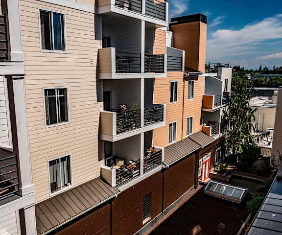 The exterior peaches and cream building with the rest of the neighborhood in the background at St. James Apartments. 