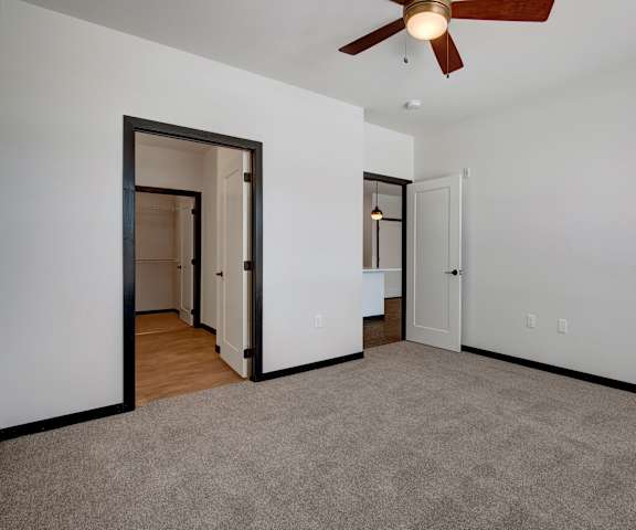A large, empty carpeted bedroom with overhead lighting and a closet at the Lafeyette Apartment Homes. 