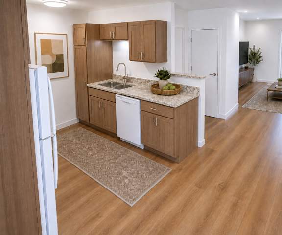 A kitchen with wooden floors and a white fridge.