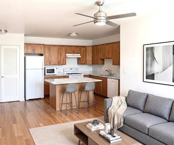 A modern kitchen with a dining table and a grey sofa.