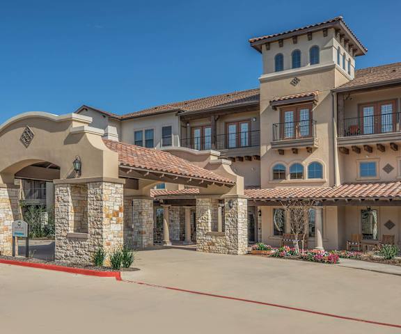 the front of a building with a street and a drivewayat Mariposa at Harris Road Arlington 55+ Apartments, Arlington, TX