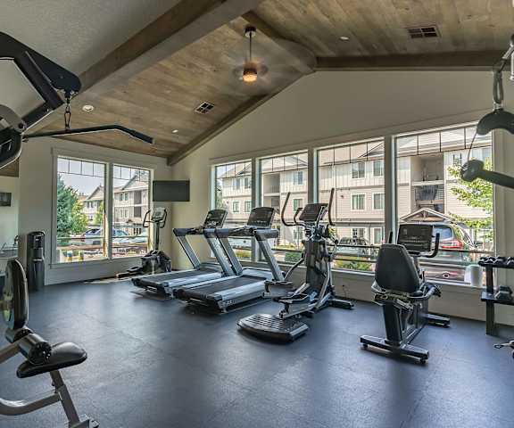A gym with a variety of equipment including treadmills, weights, and a stationary bike at Sandyplace Apartment Homes, Sandy, 97055