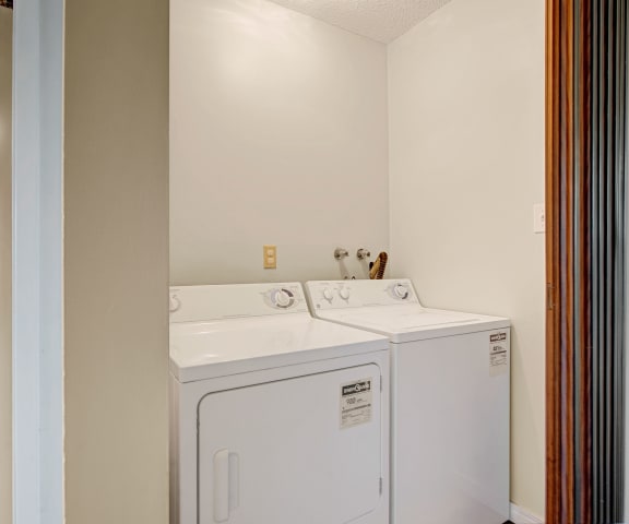 The view of a washer and dryer in a laundry room at Broadmoor Apartments.
